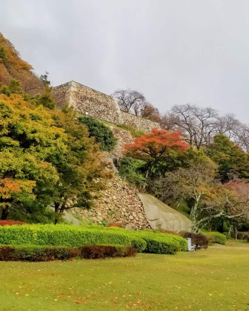 A View of the height remaining of the lower balleys of Tottori Castle Ruins with fall foliage on the trees