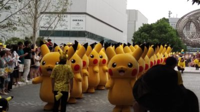 A group of people dressed in Pikachu costumes march through a crowd in Minato Mirai area of Yokohama Japan